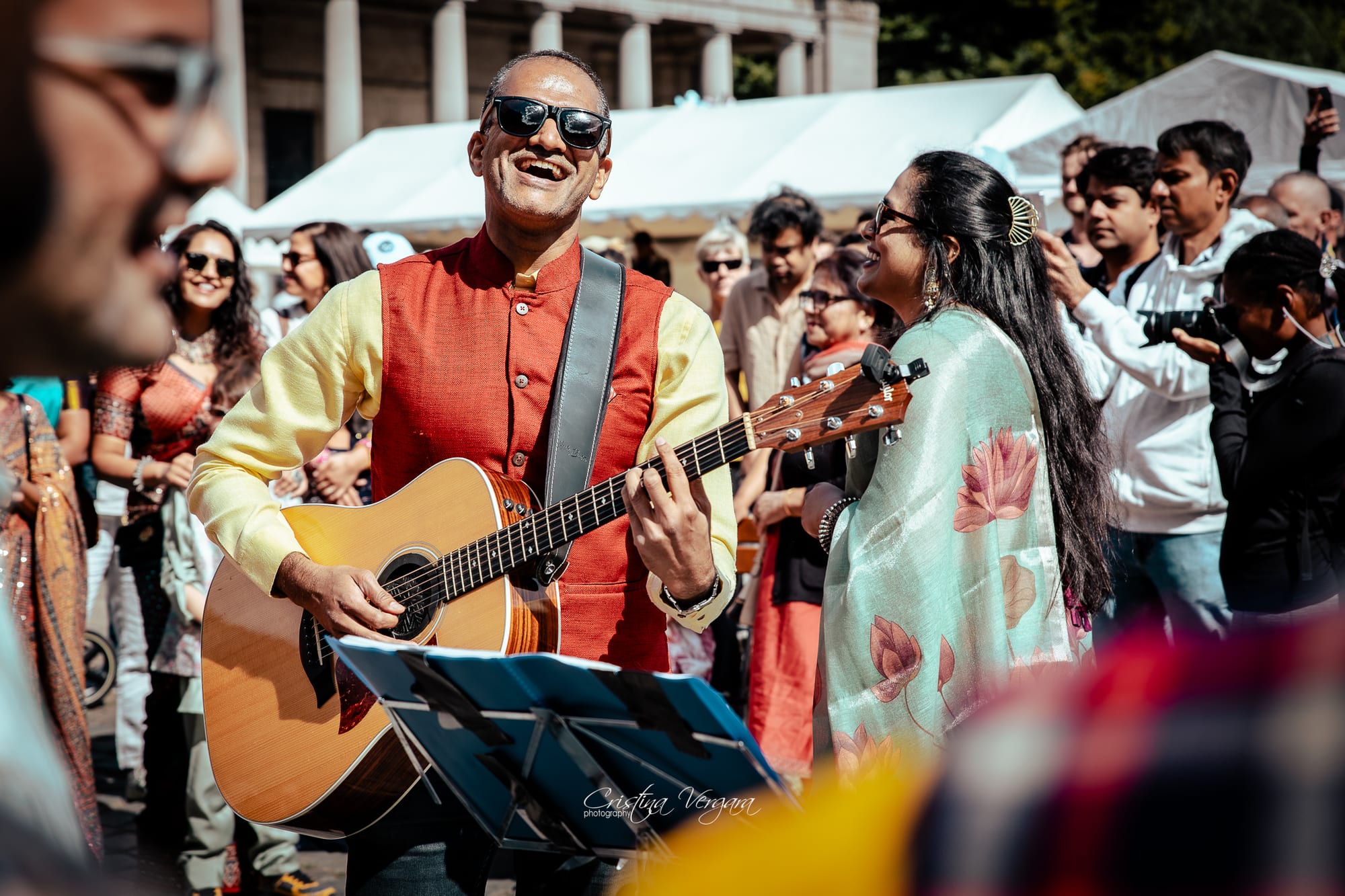 Rahul Venkit playing guitar on stage at the Cinquantenaire, Brussels
